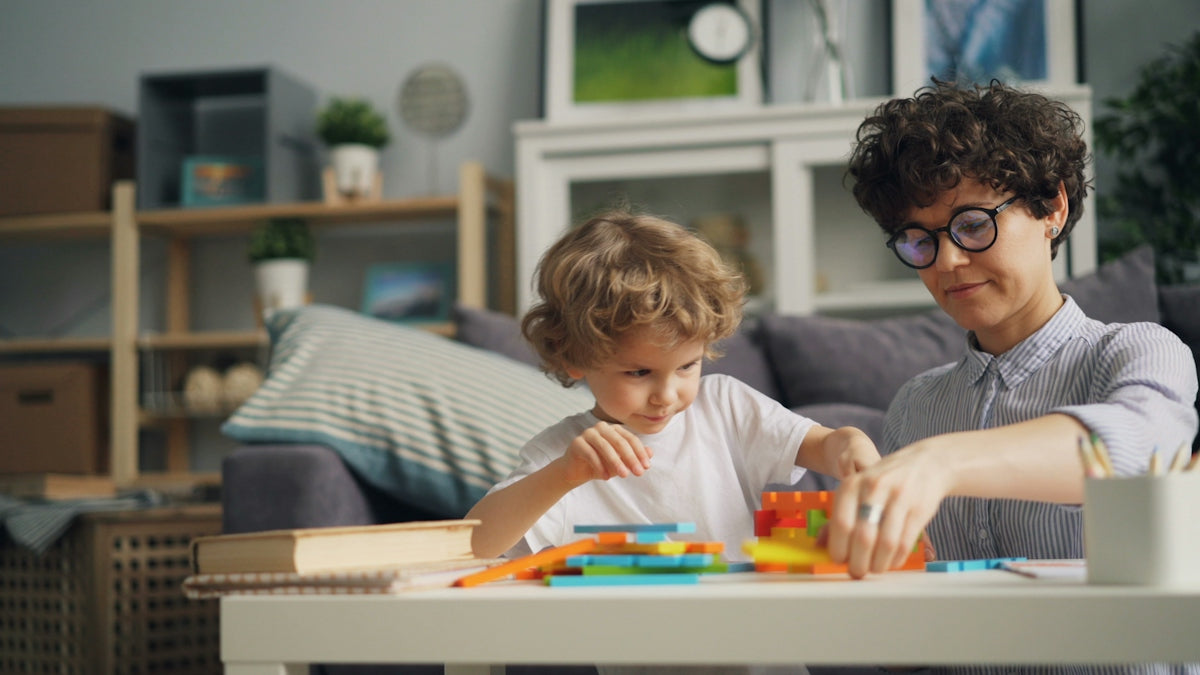 a woman playing with a child at a table