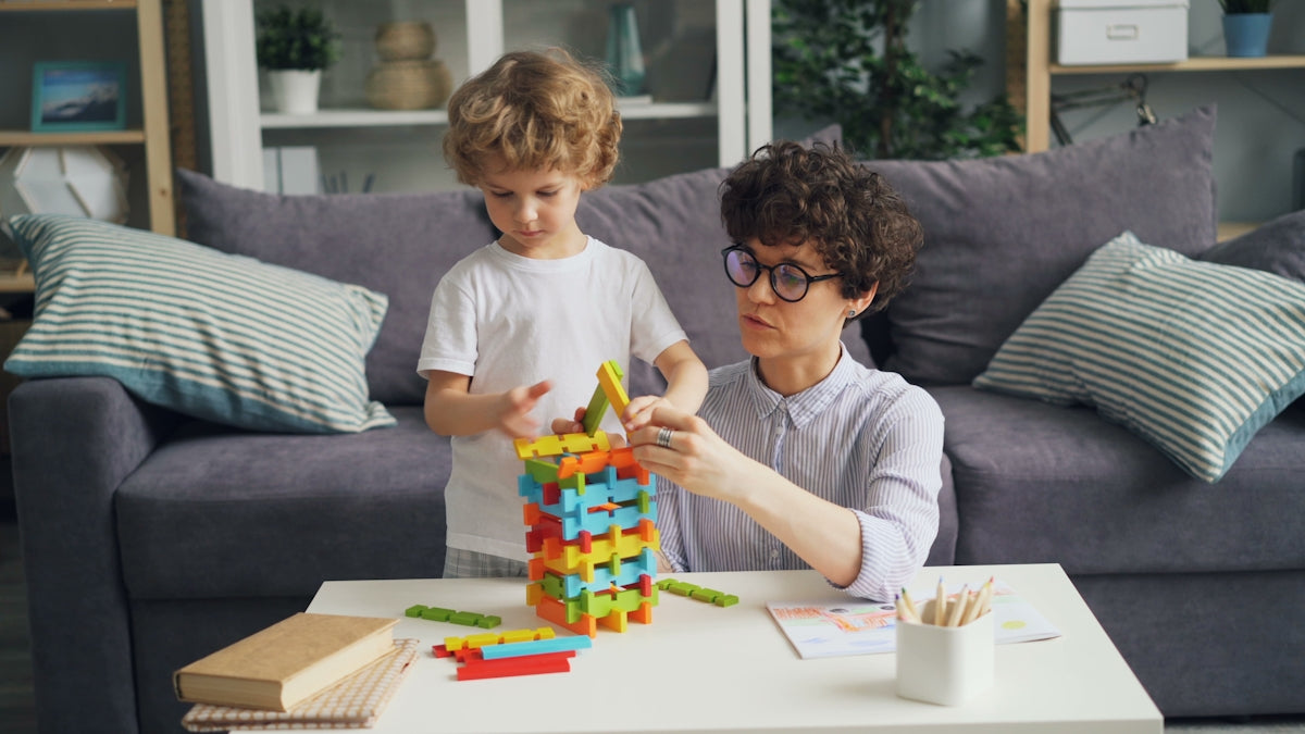 a woman and a child playing with a building set