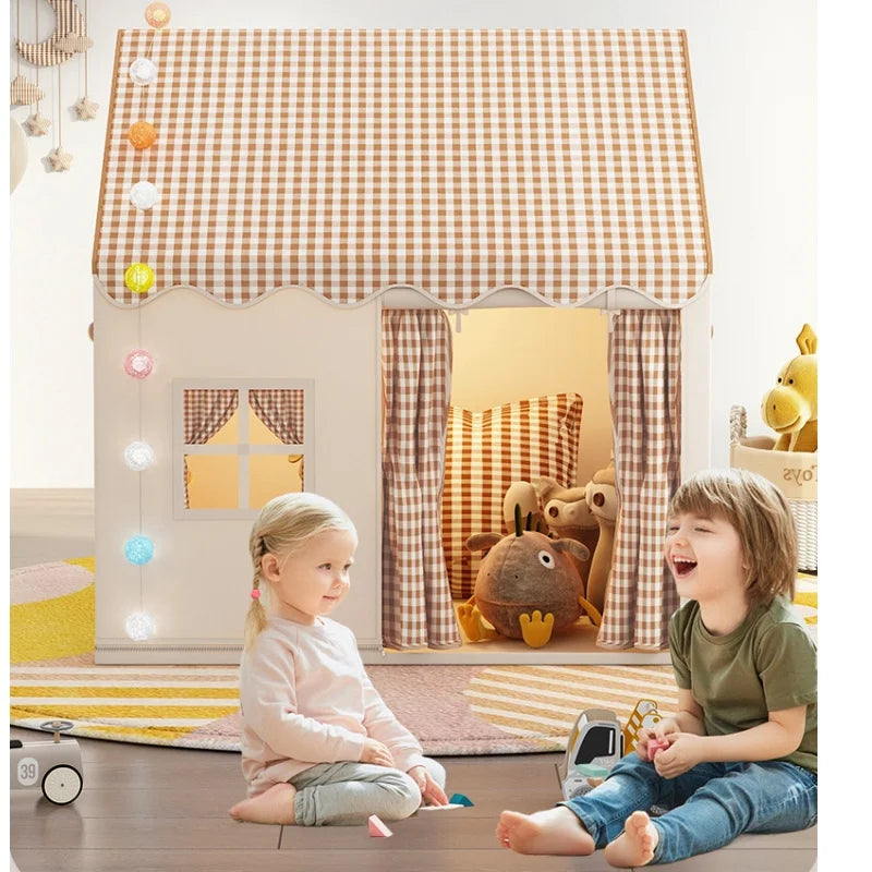 Two children sitting inside a checkered play tent with toys around.